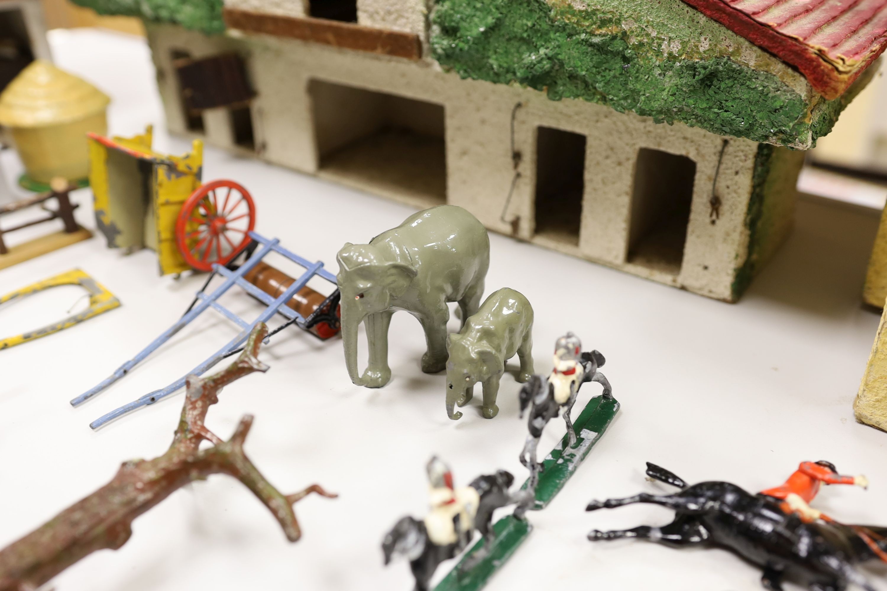 A collection of mainly Britains painted lead figures and animals, including huntsmen and hounds, farm workers, animals and wooden buildings